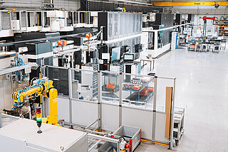 Moderne Produktionshalle mit Robotern und Fräsmaschinen