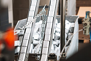 Aluminiumspäne-Briketts werden über Austragungsschiene in Sammelbehälter ausgestoßen